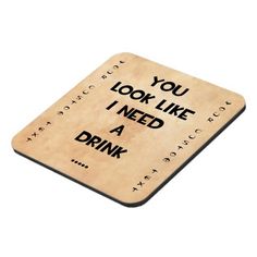 a coaster with the words you look like i need a drink written on it in cursive writing