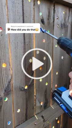 a person using a power drill on a wooden fence with bubbles coming out of it