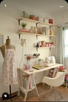 a sewing machine sitting on top of a wooden floor next to a table with a white chair