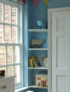 a room with blue walls and white shelves