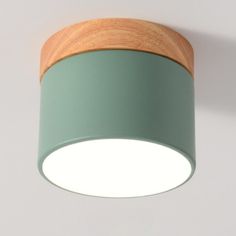 a light that is on the ceiling with a wooden base and green cover over it