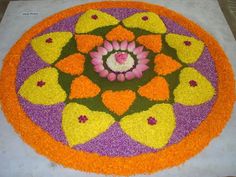 a colorful flower arrangement on the ground with petals and hearts around it, as well as flowers in the center