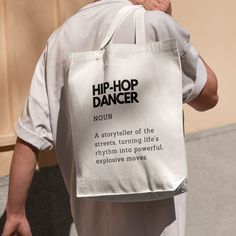 a person carrying a white bag with the words hip - hop dancer written on it