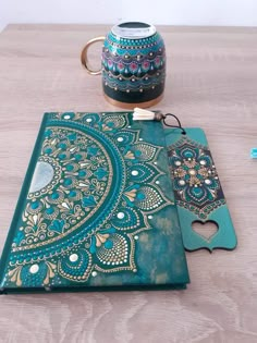 a wooden table topped with a blue and gold notebook