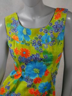 This 1970s vintage Hawaiian dress has a stunning floral pattern in blue, orange, and yellow on a green background. The sleeveless cotton summer dress has a slight scoop neckline, a relaxed-fit waistline, inverted pleats on both sides of the front, an inner back-tie so that you can fit the dress to be show your form. An 11-inch (27.94cm)zipper in the back makes dressing an ease. Size 8 US, 12 UK Bust = 36 inches (91cm) Waist = 37 inches (93.98cm), with inner tie-back if you want a more fitted look Hips = 42 inches (106.68cm) Dress Length = 35 inches (88.9cm)  Brand label: Noelani Casuals (Made in Hawaii) Material: Cotton Condition: Excellent (Professionally Cleaned ... soft and supple, with no stains, tears, wear spots, or weaknesses in the seams)   --- DESCRIPTION ASSURANCE --- I want you Hawaiian Vintage, Vintage Hawaiian Dress, Cotton Summer Dress, Vintage Tropical, Cotton Dress Summer, Hawaiian Dress, Brand Label, Vintage Hawaiian, Sleeveless Floral Dress