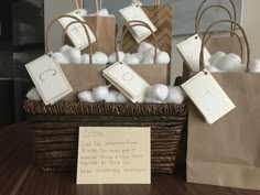 a basket filled with cotton balls on top of a wooden table next to a sign