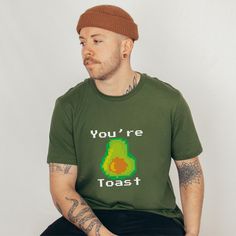 A fun and humorous avocado design with the words you're toast.  Our  Unisex Bella+Canvas shirts are manufactured in the US and internationally in humane, no-sweat-shop, sustainable way and is part of the Fair Labor Association as well as Platinum WRAP certified. Our entire process is eco-friendly. Water based inks that are bio-degradable and non-toxic are used in the direct to garment printing. Production is fully automated and paperless. Product Details: Fiber composition:  Solid Colors are 100 Cute Green T-shirt With Funny Text, Cute Avocado Shirt, Funny Print Organic Cotton T-shirt, Vegan Shirts Funny, Avocado Design, Novelty Green T-shirt With Funny Print, Funny Pun, Avocado Toast, Labor