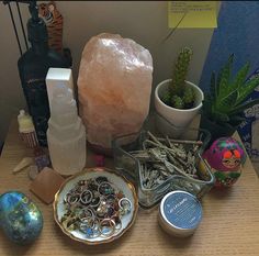 a table topped with lots of different types of jewelry next to a vase filled with succulents