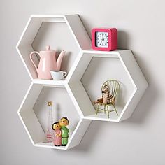 three hexagonal shelves are arranged on the wall to hold various items and decor