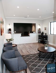 a living room filled with furniture and a flat screen tv mounted to the side of a wall