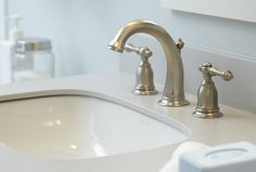 a bathroom sink with two faucets and soap dispenser