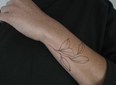 a person's arm with a flower tattoo on the left side of their arm