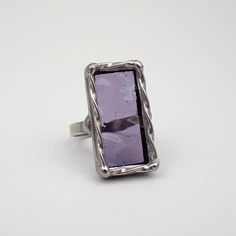 Transparent, rectangular light purple wavy stained glass ring, framed with twisted wire, edged in silver. The sterling silver wire band is approximately size 8.5. This is a one of a kind ring.  Approximate Ring Size: US 8.5 / UK Q 1/2 Center Glass Size: 1 1/16" x 9/16" Each item by Faerie Glass is 100% uniquely hand-crafted with quality materials that are lead-free. NOTE - All photographs are taken in effort to best represent the actual product. Color of actual jewelry may vary slightly from photographs. Elegant Faceted Purple Rings, Rectangular Silver Amethyst Gemstone Ring, Artistic Nickel-free Purple Jewelry, Nickel-free Purple Amethyst Ring, Nickel-free Purple Glass Jewelry, Twisted Wire, Glass Rings, Light Purple, Silver Wire