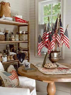 an american flag centerpiece on a table in a room with white walls and wood floors