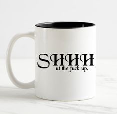 a white and black coffee mug with the words shrap on it, all the luck up