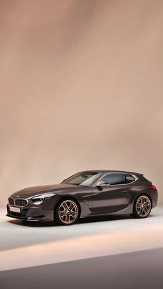 the bmw z4 roadster is parked in front of a gray background with gold rims