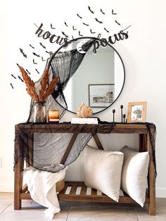 a wooden table topped with a mirror and lots of birds flying over the top of it