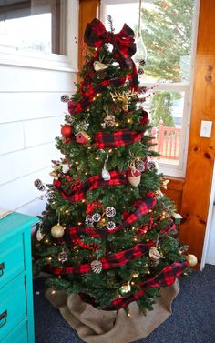 a christmas tree decorated with red and black plaid ribbon