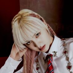 a woman with long blonde hair wearing a white shirt and red striped tie is posing for the camera