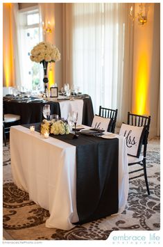 the table is set up with black and white linens for an elegant wedding reception