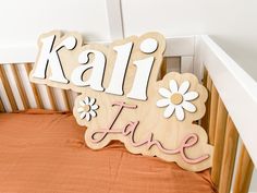 a wooden sign that says kalli fave on it in front of a crib