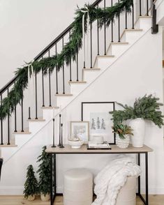 a staircase decorated for christmas with greenery