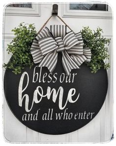 a black and white door hanger that says, blessing our home and all who enter