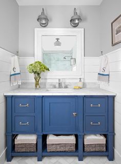 a bathroom with blue cabinets and white walls