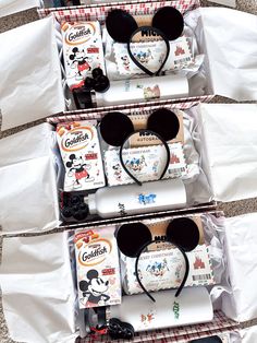 three boxes filled with mickey mouse items on top of a table