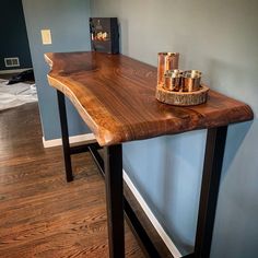 a wooden table with some gold cups on it and a blue wall in the background