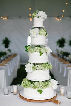 a wedding cake with white flowers and greenery