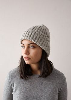 a woman wearing a gray sweater and grey hat