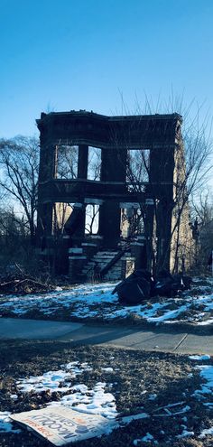 an old run down building with snow on the ground