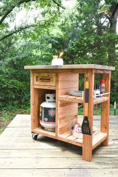 an outdoor bbq cart made out of pallet wood with a grill and tools on it