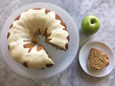 a bundt cake sitting on top of a plate next to an apple