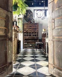 an open door leading into a room with black and white checkered flooring