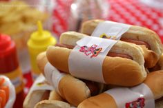 hot dogs stacked on top of each other in buns with napkins around them