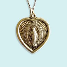 The legend of the Virgin of Guadalupe is that she first appeared to an Indigenous shepherd near Mexico City in 1531 and asked him to build a temple in her honor. Since then she’s become a beloved symbol in Mexico and beyond, representing faith, compassion and comfort to the oppressed. ⠀ Vintage Virgin of Guadalupe saint medal on aged brass curb chain. Metal: 24kt gold plate over brass on pendant, aged brass chain Size: 1" wide pendant, 18" chain Lobster Clasp The Virgin Of Guadalupe, Guadalupe Necklace, Knife Necklace, Brass Chain Necklace, Short Pendant Necklace, Antique Gold Earrings, Galentines Gifts, Virgin Of Guadalupe, Bold Statement Necklaces