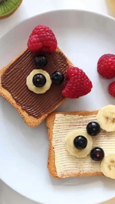 two pieces of toast with fruit on top and chocolate spread, topped with bananas and raspberries