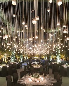 a dining room with chandeliers hanging from the ceiling and tables set for dinner