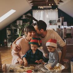 a man, woman and two children are making christmas cookies