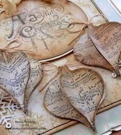 three heart shaped tags with music notes and snowflakes in the background, on top of an old sheet of paper