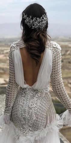 the back of a woman's wedding dress, with long sleeves and beaded details