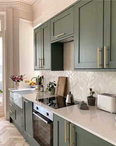 an image of a kitchen setting with green cabinets and marble counter tops on instagram