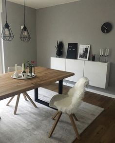 a dining room table with two chairs and a white rug