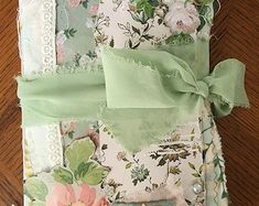 a close up of a piece of cloth with flowers on it and green ribbon around the edge