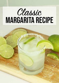 a margarita with limes and salt on a cutting board next to some tortilla chips