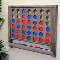 a giant four in a row board game with red, white and blue dots on it