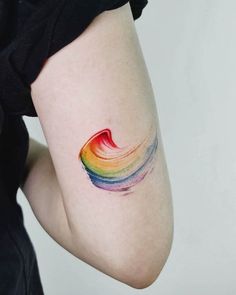 a woman's arm with a rainbow tattoo on the left side of her body