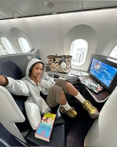 a woman sitting on an airplane with her feet up